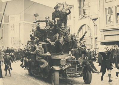 879258 Afbeelding van een Utrechtse vrachtwagen, volgeladen met bevrijders en feestvierende mensen tijdens de intocht ...